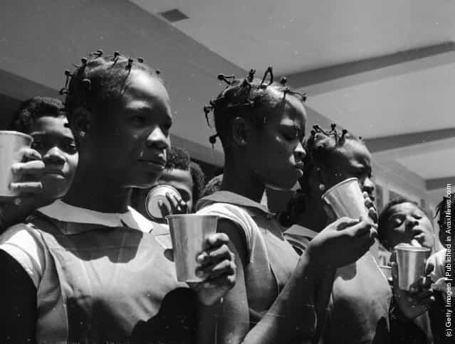 June 1959: Pupils take milk break at Queens College in Yaba, Lagos, Nigeria, a state secondary school for girls