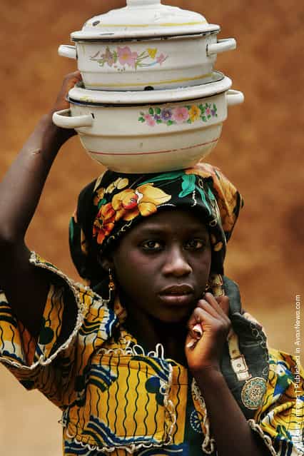 A Nigerian girl carries pots on her head in a remote area of Nigerias Muslim north April 9, 2005 in Rimin Gado, Nigeria. Polio, a disease that health workers once had hoped to eradicate worldwide by 2005, is on the march again in Nigeria, especially in this region, where local Islamic leaders banned the polio vaccine two years ago over post September 11 suspicions of everything Western. Inoculations have resumed and Nigeria will undertake a massive countrywide push to inoculate every child under five with nearly 4 million doses of polio vaccine in four days