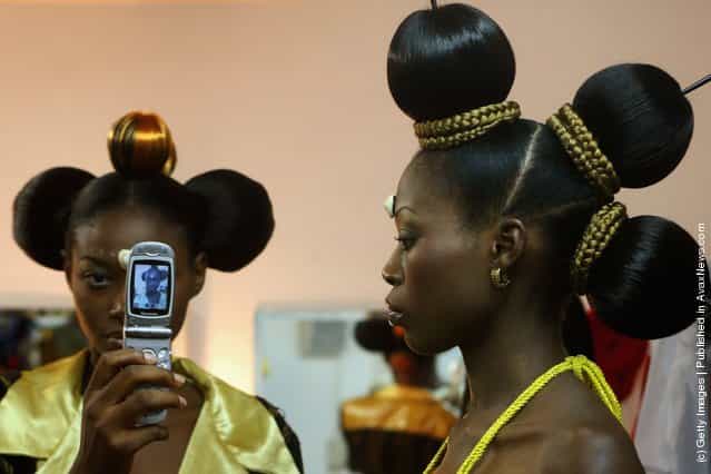 Nigerian fashion models Mary Jane Unueroh and Fome Emede (L) take a photo themselves with a cell phone behind the curtain during their fashion show to promote ethnic fashion June 13 in Tel Aviv, Israel