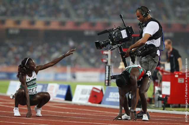 Gold medalist Muizat Odumosu of Nigeria points to a camera as she celebrates winning the womens 400 metres hurdles at Jawaharlal Nehru Stadium during day seven of the Delhi 2010 Commonwealth Games on October 10, 2010 in Delhi, India