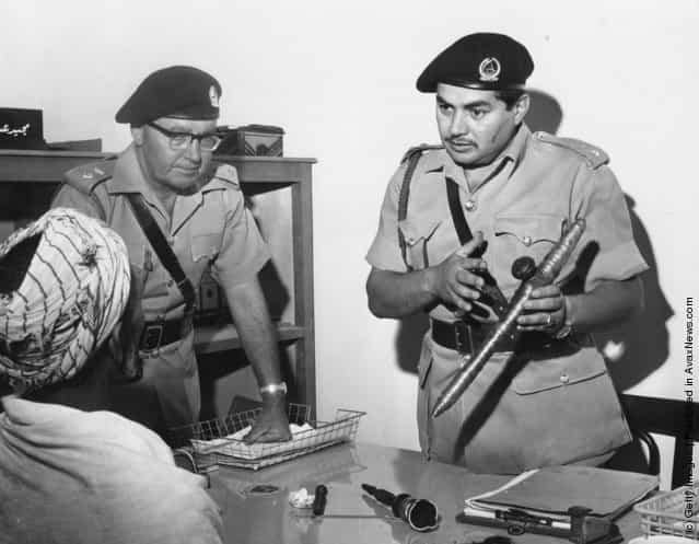 1967: Two members of the Dubai police force questioning a man about an opium pipe