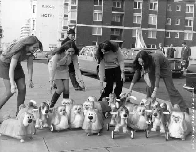 Toy rubber dogs, including several models of Dougal from The Magic Roundabout being demonstrated by four young women, on the pavement outside the Brighton Toy Fair, 1969