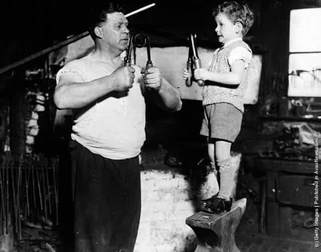 A young boy and his father building up their muscles, 1935