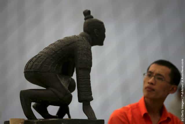 A visitor views the sculpture New Beijing, New Starting Point at the Olympic Sculptures Exhibition at Window of the World theme park
