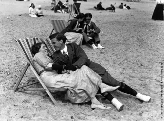 A couple relax in their deckchairs on the beac, 1913