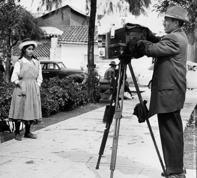 A street photographer preparing to take a picture of a Peruvian girl, 1950