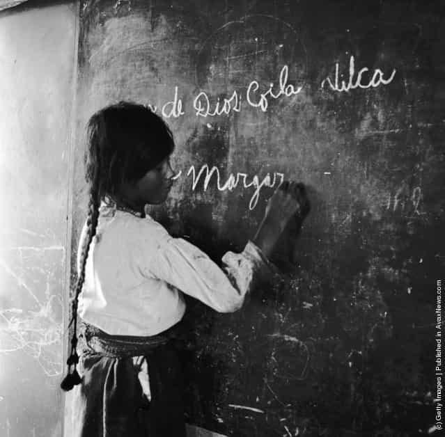 A schoolgirl writes at the blackboard in an Adventist school on the reed island of Urso, on Lake Titicaca, Peru, 1950