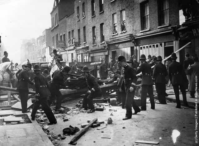 British policemen dismantle a barrier near Mark Lane, London, 1936