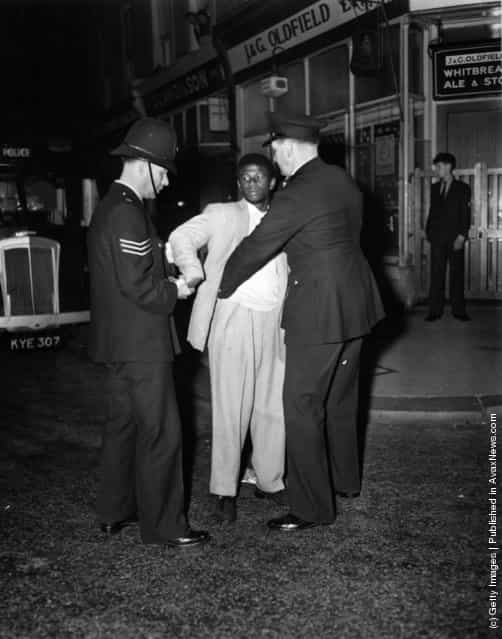 London police search a black youth in Talbot Road, Notting Hill during race riots, 1958