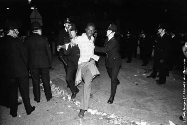 Police arresting a young black man during riots at the Notting Hill Carnival in west London, 1977