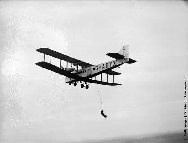 A man dangles from a rope suspended from a flying aircraft