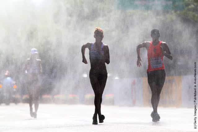 Athletes run through a mist station during the womens 20km race walk during day five of the 13th IAAF World Athletics Championships in Daegu
