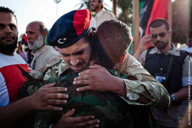 Libyan rebels soldiers embrace as they grieve at Martyr Square formerly known as Green Square, for the Eid Al-Fitr prayer