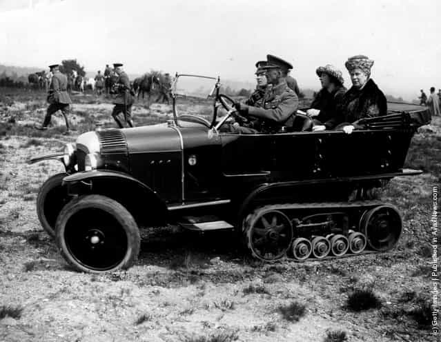 Queen Mary with Princess Mary, the Princess Royal being driven across rough ground in a tracked car by Army officers