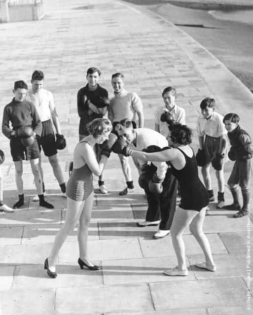 1935: Two female members of a keep fit group learn boxing techniques as part of self defence lessons