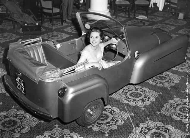 1955: Model Gay McGregor shows off the latest 1956 model Bond Minicar three-wheeler, at its London preview