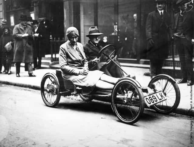 1929: A man and a woman riding in an Auto Red Bug, Americas latest electric 2-seater runabout, in a London street