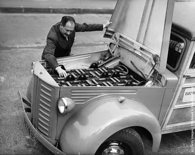 1948: A man examining his electric car