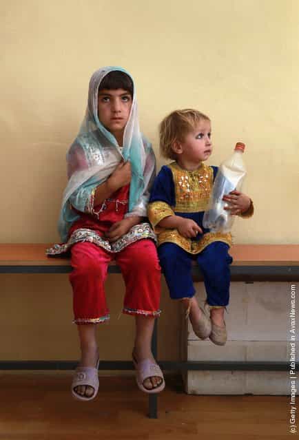 Afghan children wait as their mothers receive treatment at a USAID-funded health center