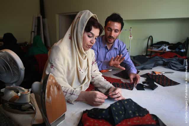 Afghan master tailor Ahmed Jamshid Naser instructs Habiba Uthri in making finished garments at the Afghan Women Business Council