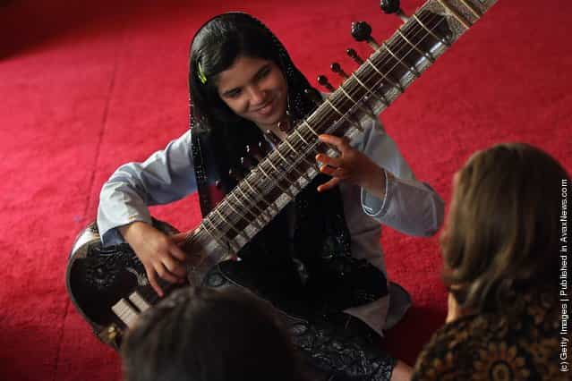 Houma Rahimi, 12, plays the sitar during music class at a USAID-funded after school program for children affected by the Afghan war