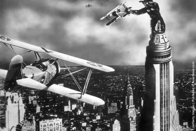 A scene from the film King Kong with the giant gorilla astride a Manhattan skyscraper grabbing a passing aeroplane