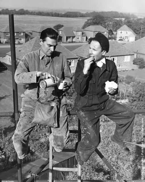 Builders Frank Agate, left, and Peter Stenning, enjoy their lunch high up on the scaffolding surrounding Moepham Windmill, at Moepham in Kent, which is being restored by Kent County Council