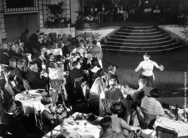 Diners and a cabaret performer in the ballroom at Palm Beach Cafe on the Thames