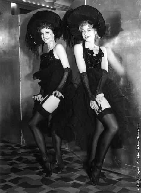 Two Can-Can dancers adjusting the suspenders on their stockings