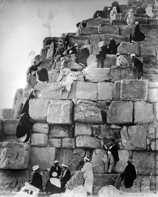 Egyptians clambering up the rock slabs of a pyramid, 1880