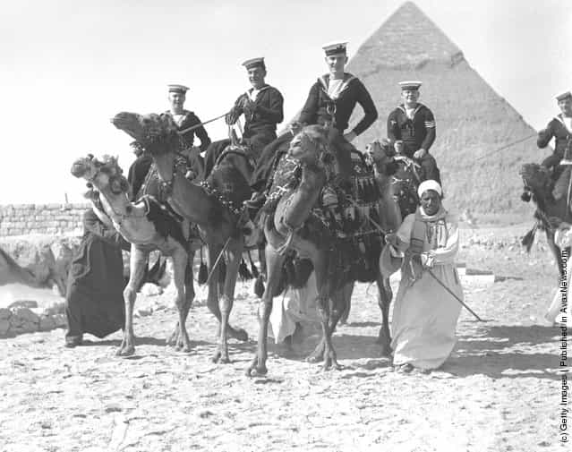 1937: Members of the British Navy enjoying a camel-ride in front of one of the pyramids, near Cairo, Egypt