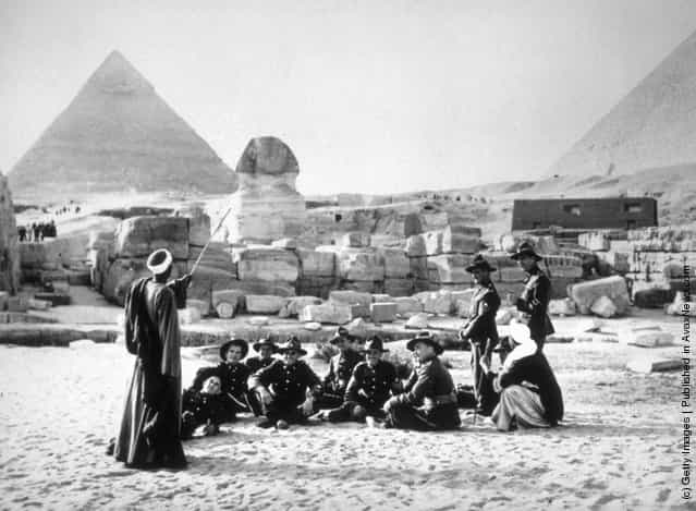 1940: Members of the New Zealand forces resting with their native guides during a visit to the Sphinx and the Pyramids at Giza