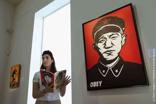 A Bonhams intern stands beside a work entitled Chinese Soldier by Shepard Fairey