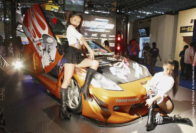Models display a car to promote the game Need For Speed Underground 2
