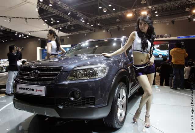 Models poses next to a GM Daewoo Motor's Winstorm Sport car