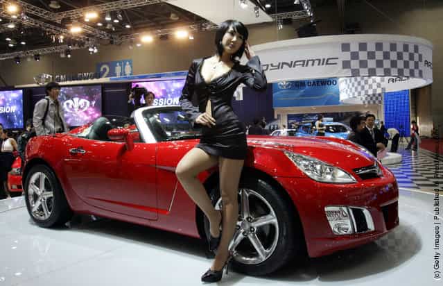 A Model poses next to a GM Daewoo Motor's Sport car at the Seoul Motor Show