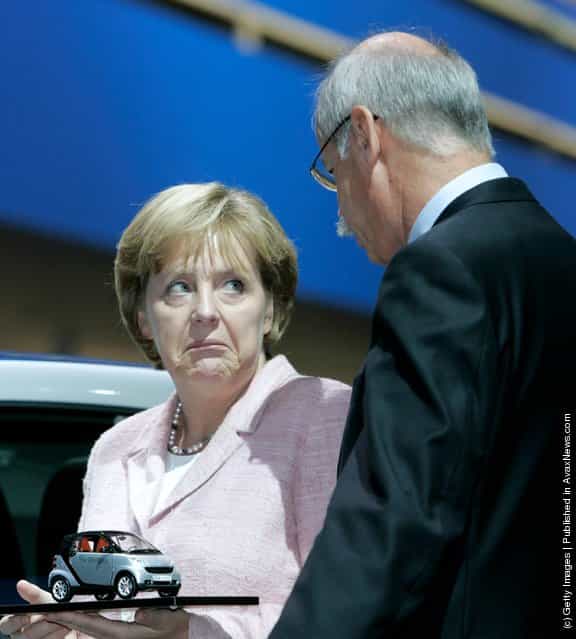 German Chancellor Angela Merkel holds a model of a Smart car