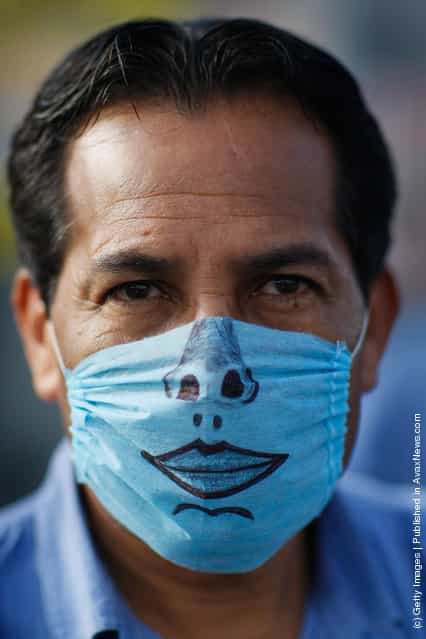 A drawing adorns the surgical mask worn by a man to help prevent being infected with the swine flu