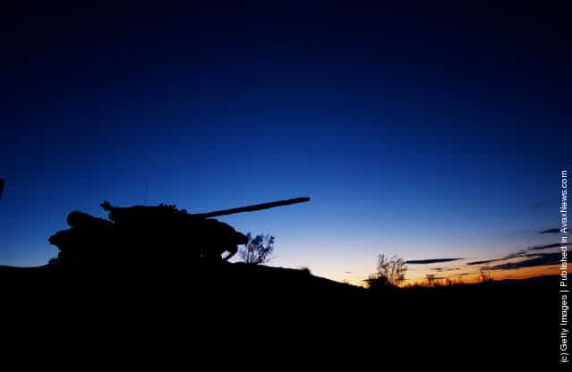 Pre-dawn glow silhouettes a tank on display at the entrance to the U.S. Armys Fort Irwin Military Reserve