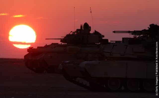 U.S. Army armor maneuvers at sunset near the Iraqi border in northern Kuwait