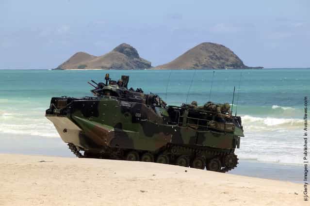 A U.S. military Amphibious Assault Vehicle (AAV) from the USS Rushmore rolls up on the beach