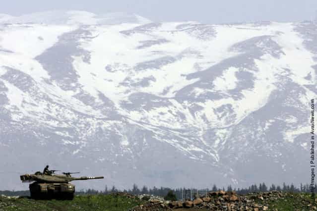 An Israeli army Merkeva tank is seen against the snow-clad Mt. Hermon during a training exercise