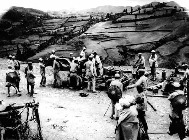 1939: Chinese soldiers and labourers carry parts of an American leased Jeep over mountain trails for re-assembly on the repaired section of the Burma Road in China