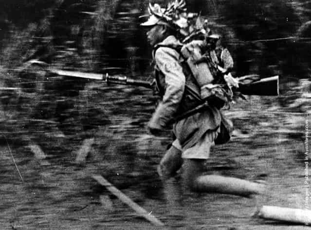 1942: A Chinese soldier in camouflage runs towards a new position somewhere in Burma