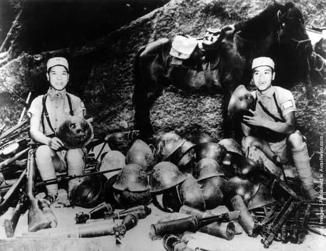 1943: Chinese soldiers showing off a collection of Japanese tin helmets after defeating the Japanese in the Battle of the Upper Yangtze. The horse in the background is also a captured trophy