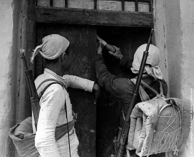 1944: Two Chinese Red Army militia men plant a potato masher grenade in a farmers doorway as a killer trap