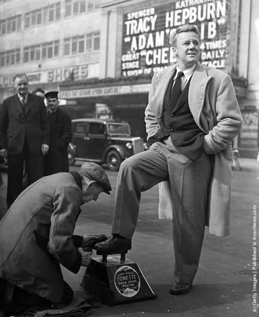 1950: American film star Van Johnson gets a quick polish from a street shoeshine