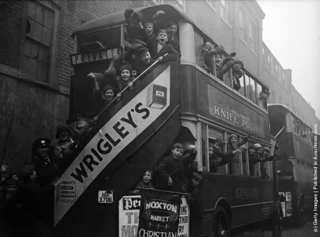 1931: 150 children from the Hoxton Market Mission in London set off for Queens Gate by bus to attend a Christmas tea and gift-giving session at the mansion of Mr C A Simpson. The rear bus sports a large poster advertising Wrigleys Chewing Gum