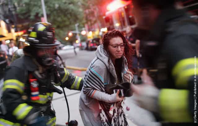 New York City firefighters rescue a woman from a building fire