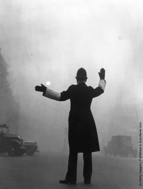 A policeman on traffic duty on a foggy day in Fleet Street, London, 1952